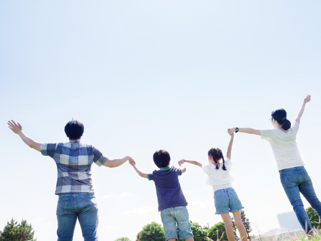 4人家族が手をつないで並んでいます。